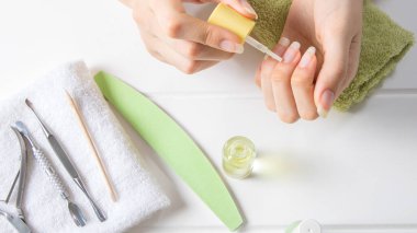 Manikür. Tırnak altlarını boyanmamış tırnaklara sürün. Nemlendirici. Evde tırnak bakımı. Güzellik salonu, prosedür, SPA. Güzellik, tarz, makyaj, moda, yaşam tarzı.
