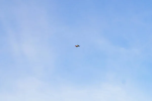 Mały quadcopter w locie pod niebem, strzelanie z powietrza, obserwacja — Zdjęcie stockowe
