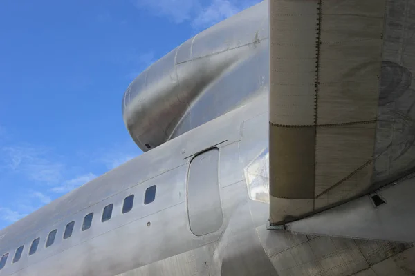 Rear view of old commercial airplane with blue sky