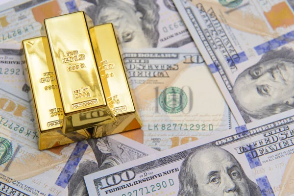 Tres lingotes de oro con billetes de cien dólares —  Fotos de Stock