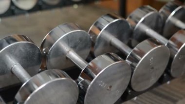 Spor salonunda bir sıra dambıl.