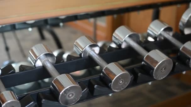 Muchas mancuernas deportivas en el gimnasio — Vídeos de Stock