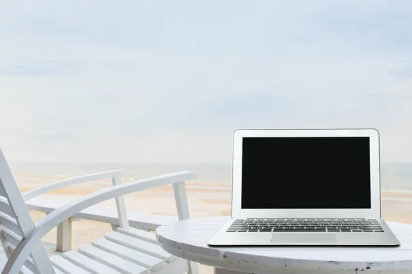 Ufficio di lavoro mobile sulla spiaggia con schermo del computer portatile vuoto — Foto Stock