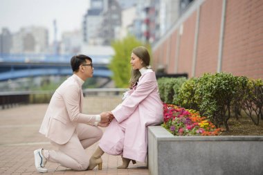 Dizlerinin üzerinde adam yolda kadınla evlenmek için bir teklif yapar