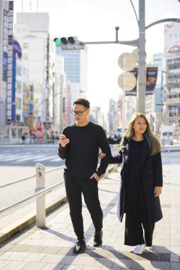 Japonya'da bilgi için bir yolda kullanım smartphone içinde genç Çift