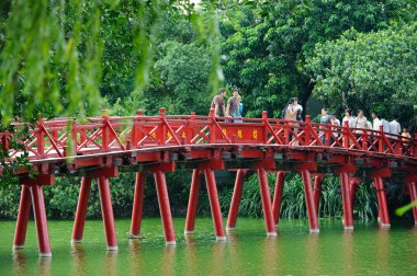 Hanoi, Vietnam - October 14, 2010 : Hanoi red bridge. The wooden red painted bridge over the Hoan Kiem Lake connects the shore and the Jade Island on which Ngoc Son Temple stands. Hanoi on October 14, 2010 clipart