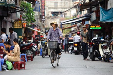 Hanoi, Vietnam - 14 Ekim 2010: Tanımlanamayan Vietnamca kadınlar binmek bisiklet Hanoi sokaklarında