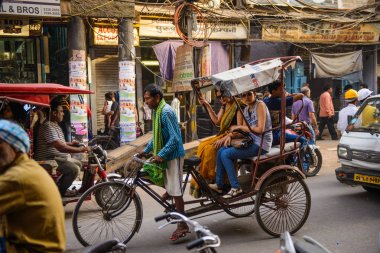Yeni Delhi, Hindistan - 16 Nisan 2016: Çekçek binici taşımaları yolcu 16 Nisan 2016 tarihinde Yeni Delhi, Hindistan. Döngüsü rickshaws Delhi'de 1940 başlanan ve lisanslarının sabit bir kota var.
