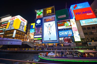 Osaka, Japonya - 27 Mart 2015: Kentsel sahne Kansai Gulico reklam Japonya'nın Osaka etrafında neon ışık ile gece modern binasında