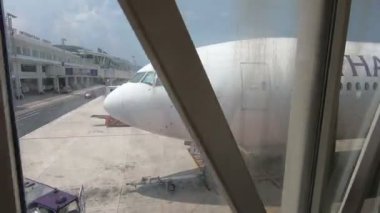 Phuket, Tayland - 29 Mart 2018: Yürümek-den geçerek jet köprü için Tay Airways Boeing 777-300er Phuket Uluslararası Havaalanı'nda yatılı