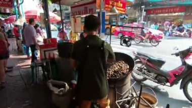 Bangkok, Tayland - 6 Mart 2018: Kestane sokak chinatown veya Yaowarat Road Bangkok, Tayland kavurma bir adam işçi el hareketi