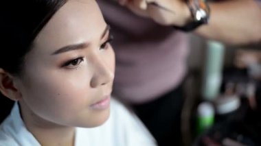 Modelinin göze rimel koyarak sanatçı makyaj