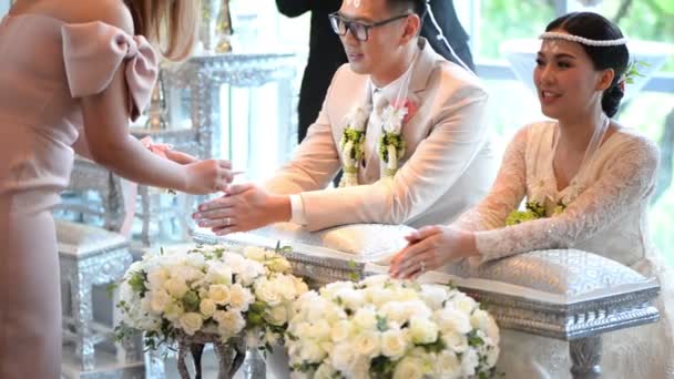 タイの結婚式の新郎と新婦のバンドに恵みの水を注ぐを手にアジアの花嫁 — ストック動画