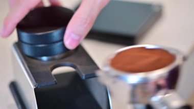 4k Barista kahve yapmak için taze öğütülmüş kahve yapıyor.
