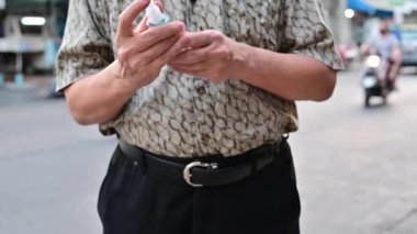 4K Asyalı adam ellerini yıkamaya alternatif olarak alkol kullanıyor.