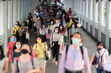 Bangkok 'ta yoğun saatlerde koronavirüs salgınını önlemek için cerrahi maske takan işadamları