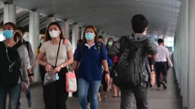 4K kalabalık Asyalılar yaya geçidinde yürürken yüz maskesi takıyor