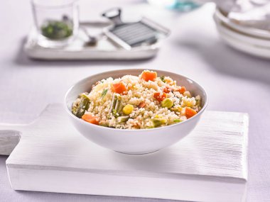 Mutfağın arka planında sebzeler olan kuzen.