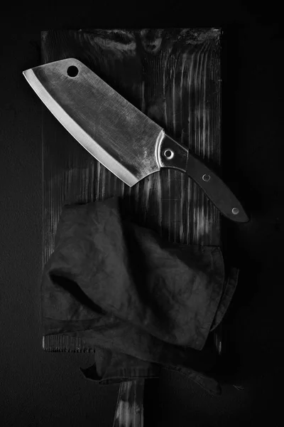 Нож повара на темном фоне с льняной салфеткой — стоковое фото