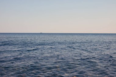 Mavi gökyüzü ufkuyla sakin bir deniz.