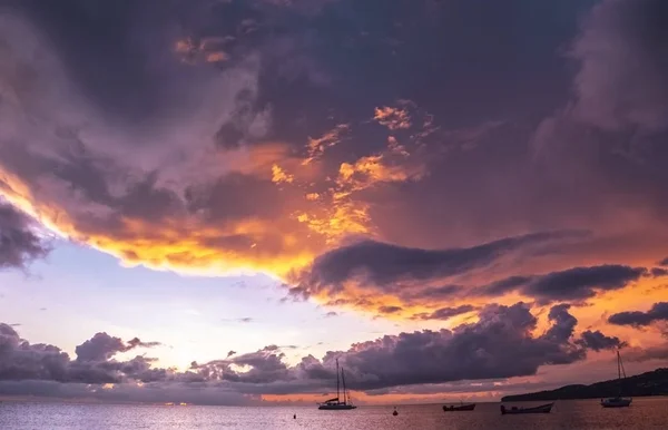 Panorama of beautiful sunset over ocean and sailboats