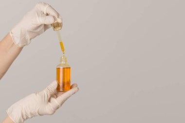 Elleri yağlı küçük bir şişe tutuyor.