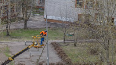 Kazan, Rusya - 30 Nisan 2020: özel bir makinede bir adam ağaç dalları kesti.