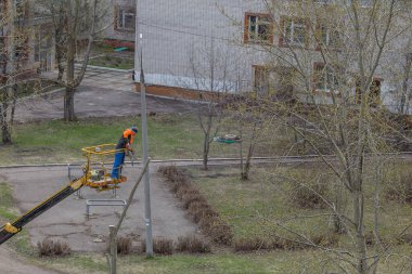 Kazan, Rusya - 30 Nisan 2020: özel bir makinede bir adam ağaç dalları kesti.