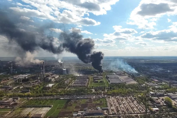 major fire at the factory. dark puffs of smoke from buildings.