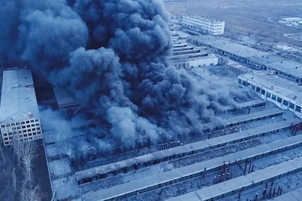 Grande incêndio na fábrica. sopros escuros de fumaça de edifícios . — Fotografia de Stock