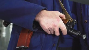 Bir güvenlik görevlisinin eli Kalaşnikof 'un üzerinde. Silahlı kuvvetler muhafızları.