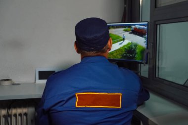 Güvenlik görevlisi kameranın monitöründe oturuyor..