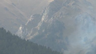 Acil Durum Bakanlığı helikopteri orman yangınını söndürmek için su topluyor.