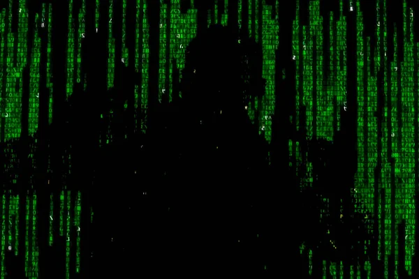 Silhouette of man in green digital data. The symbol of a hacker