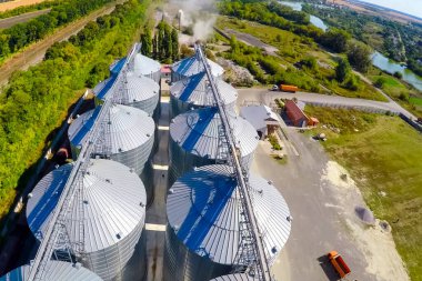 Flight of the grain terminal from the drone. The grain plant for storage and drying of grain. Grain terminal. Plant for the drying and storage Rice plant in the middle of fields. clipart
