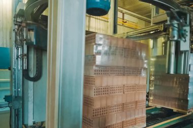 Bir tuğla paletin nakliye filmini paketliyorum. Tuğla üretimi, içi boş tuğla fabrikası. Tuğla üretimi, tuğla fabrikası.