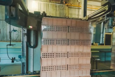 Bir tuğla paletin nakliye filmini paketliyorum. Tuğla üretimi, içi boş tuğla fabrikası. Tuğla üretimi, tuğla fabrikası.