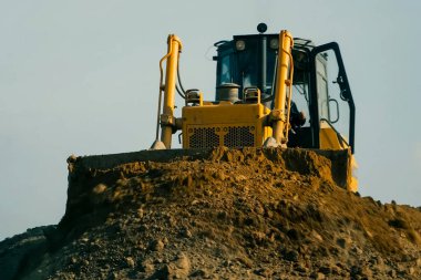 Grader taş ocağında kil taşır. Kil ocağı, tuğla üretimi için kil çıkarmak için kil ocağı..