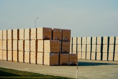 Tuğlalar açık hava deposunda saklanıyor. Paletlerde kırmızı tuğla.