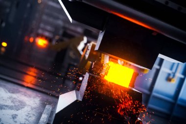 Baskıda sıcak metal çubuk var. Metal ürünleri üreten bir fabrikanın taşıma hattı.