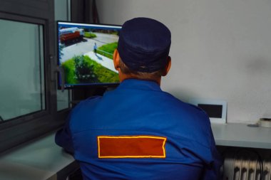 Kapalı devre kamerasının önünde bir güvenlik görevlisi oturuyor..