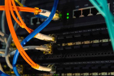 Çalışan bir sunucu. Sunucudaki internet kabloları ve yanıp sönen ışıklar.