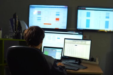 Hacker monitörün arkasında oturur ve çalışır. Bilgisayar teknisyeni ve programcının işi..