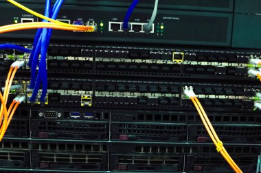 Çalışan bir sunucu. Sunucudaki internet kabloları ve yanıp sönen ışıklar.