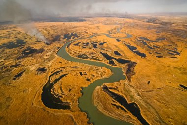 Tundra yangını. Kuru otları ve turba bataklıklarını yakmak, tundrada ateş ve duman çıkarmak.