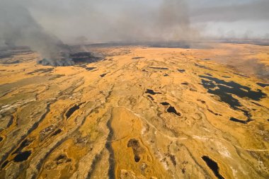 Tundra yangını. Kuru otları ve turba bataklıklarını yakmak, tundrada ateş ve duman çıkarmak.