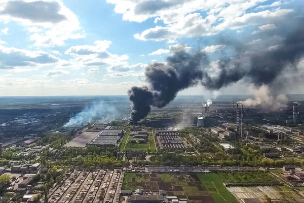 A major fire at the factory. dark puffs of smoke from buildings.