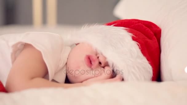 Kind slaapt met kerstmuts en wachten Santas cadeau. Vreedzame kind — Stockvideo