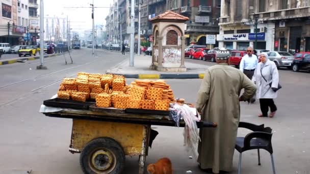 アレクサンドリア エジプト 2017 高齢者ベンダー アレクサンドリアで Galabeya ローブ Mahta Raml トラム駅に隣接する広場でぼろぼろのカートから販売しているパンを着た — ストック動画