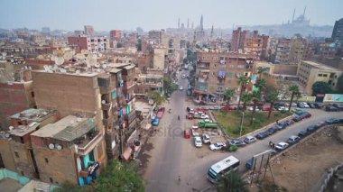 Cairo, Mısır - 22 Aralık 2017: Uzun boylu Minare Amir Sarghatmish medrese açar görünümünün üzerinde 22 Aralık Kahire, Mısır arka plan üzerinde eski püskü Al Khoderi Caddesi ile yoksul konut ve Selahaddin Eyyubi Kalesi.